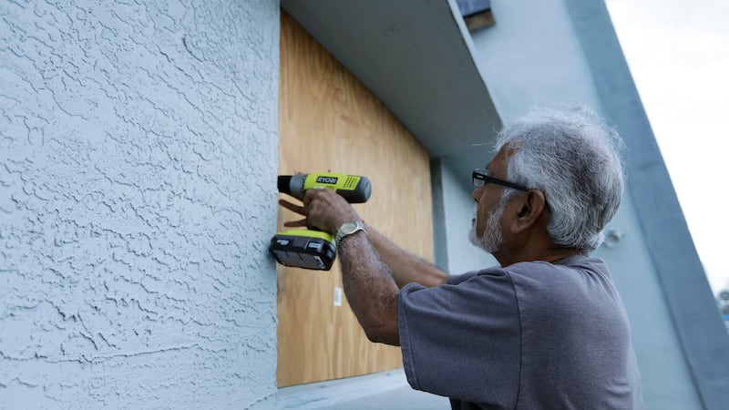 Ray Gohill, owner of the Sahara Motel, does some last minute boarding up of his windows...